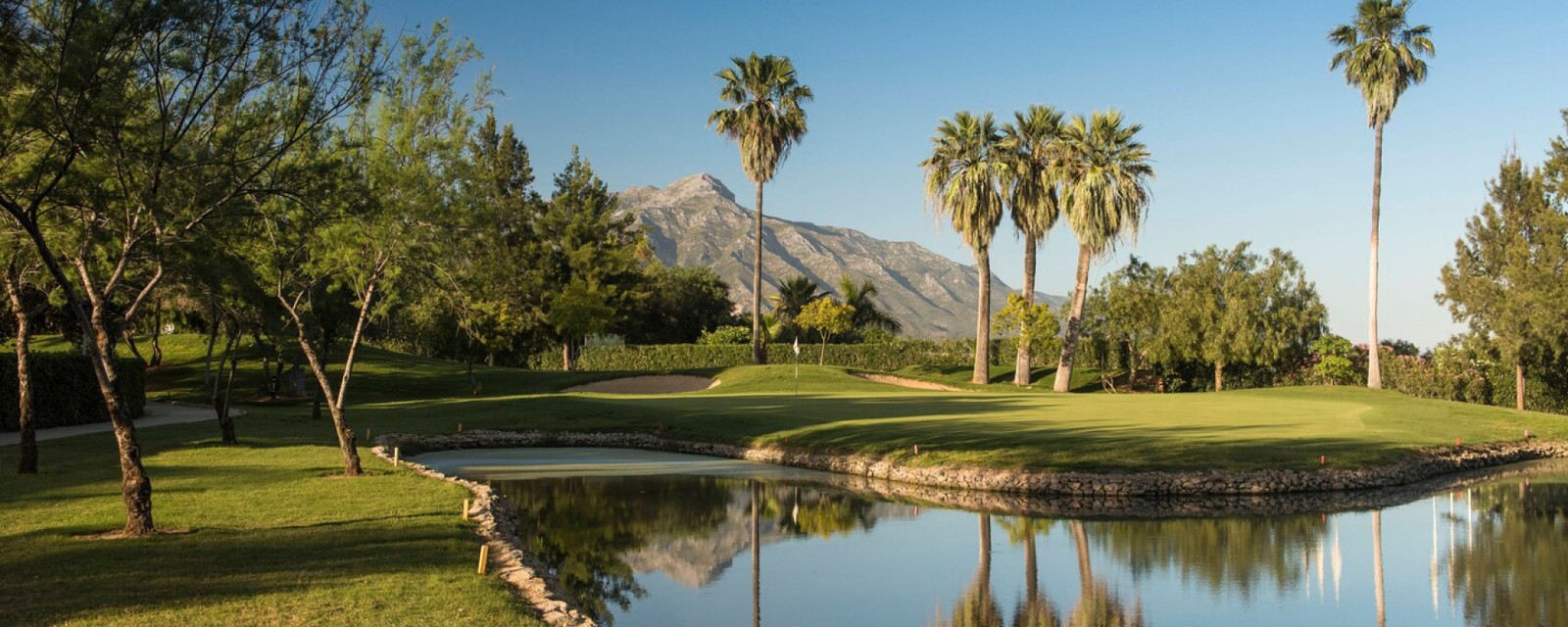 Undulating fairways at La Quinta Golf with sea and mountain views at golden hour