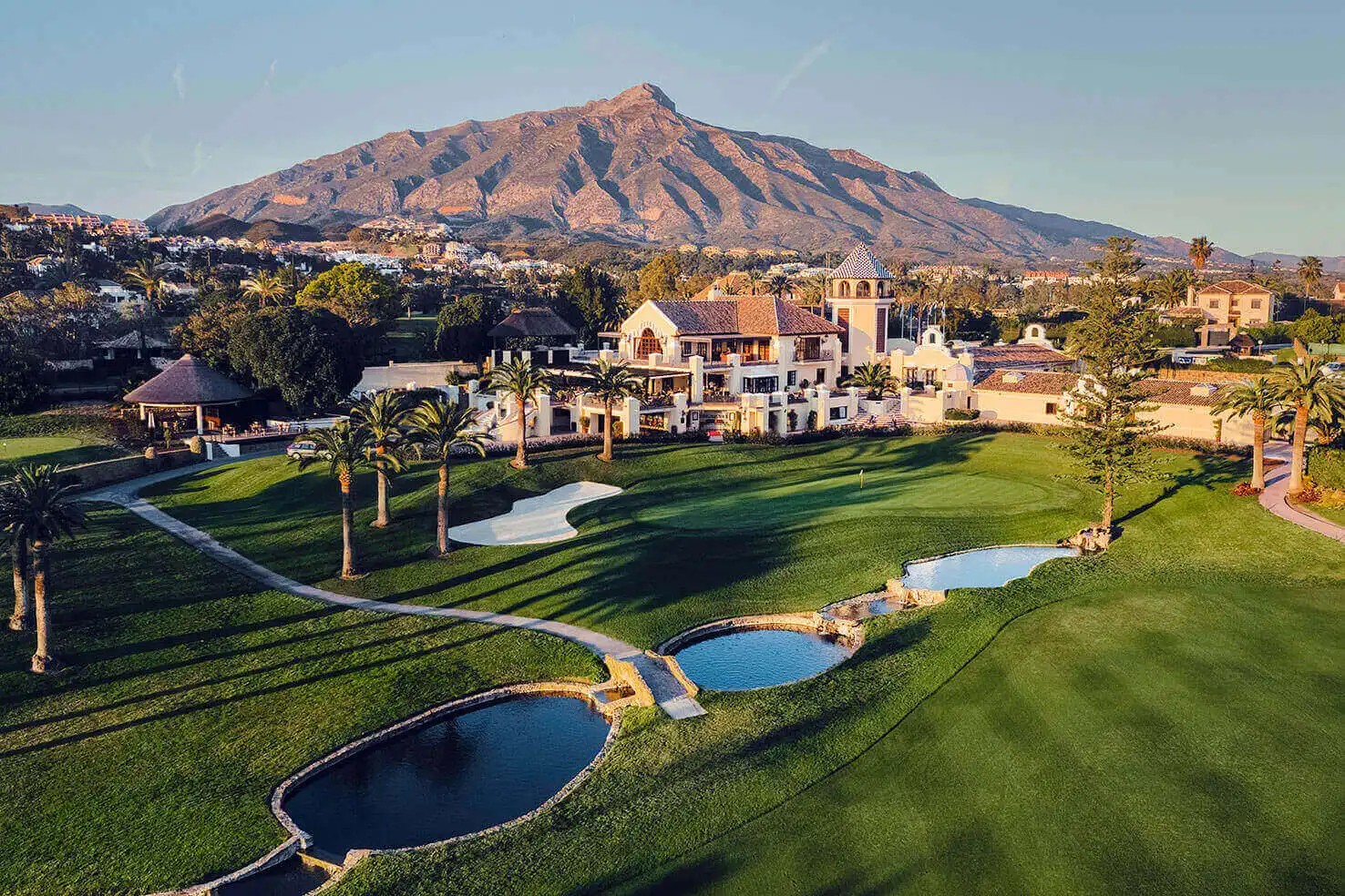 Aerial view of Los Naranjos Golf Club fairways in Marbella at golden hour